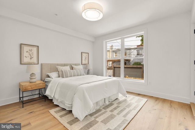 bedroom with light wood-type flooring and baseboards