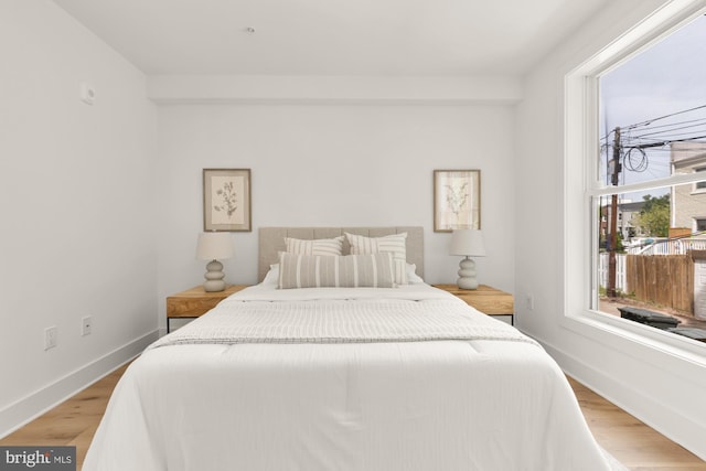 bedroom with light wood finished floors and baseboards