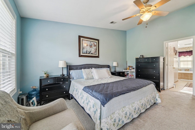 carpeted bedroom featuring a ceiling fan and connected bathroom