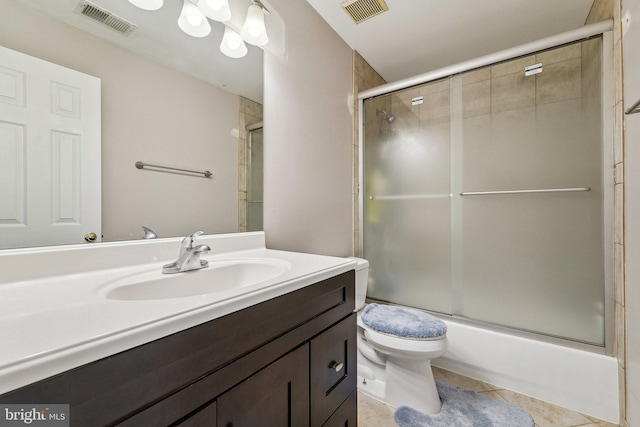 bathroom with toilet, tile patterned flooring, vanity, and combined bath / shower with glass door