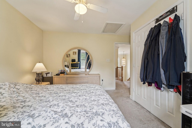 bedroom featuring light colored carpet, attic access, and baseboards