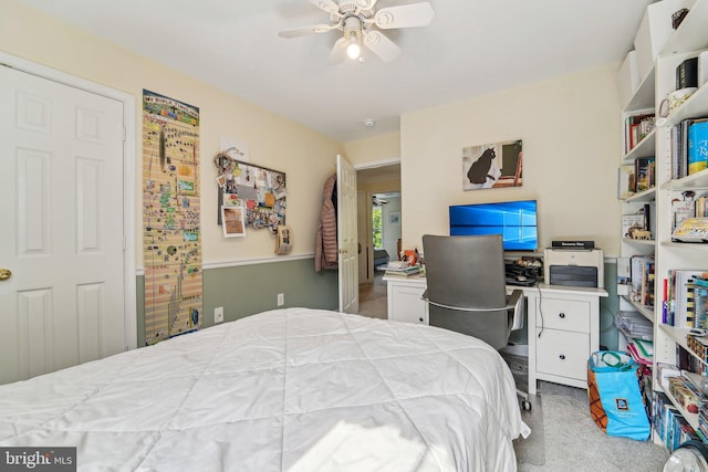bedroom featuring carpet, an office area, and a ceiling fan
