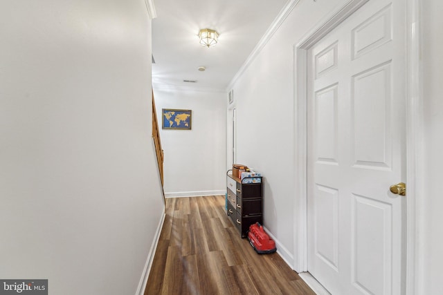 hall featuring dark wood-style floors, baseboards, and crown molding