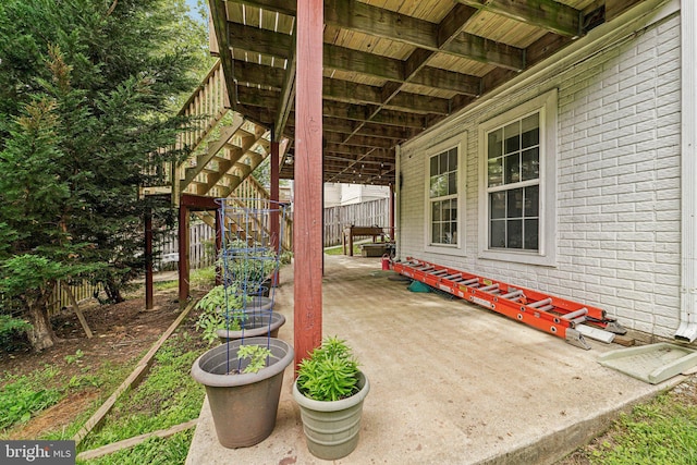view of patio featuring stairway and fence