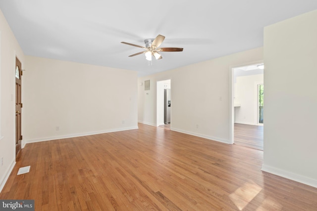 unfurnished room with a ceiling fan, light wood-type flooring, and baseboards