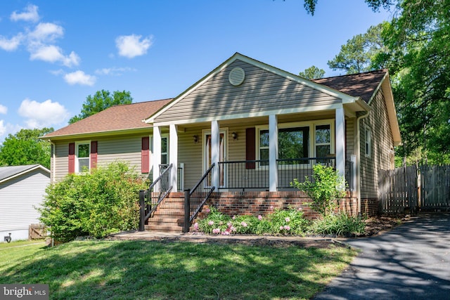 bungalow featuring covered porch and roof with shingles