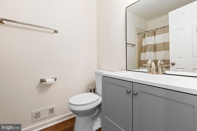 full bathroom with toilet, wood finished floors, vanity, baseboards, and curtained shower