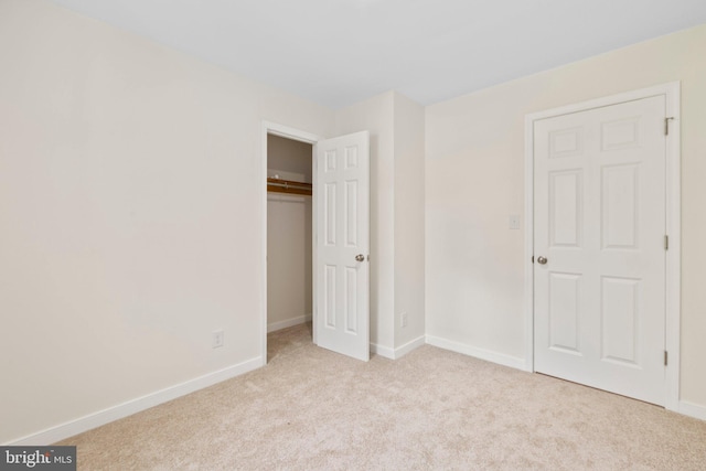 unfurnished bedroom featuring carpet, a closet, and baseboards