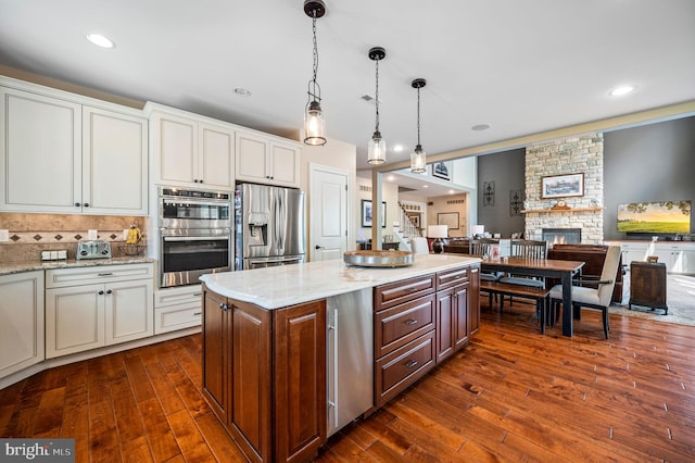 211 Dutton Mill Rd, West Chester, PA 19380 - kitchen featuring appliances with stainless steel finishes, open floor plan, dark wood-style flooring, a stone fireplace, and recessed lighting