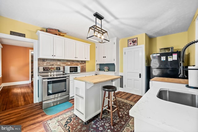 211 Dutton Mill Rd, West Chester, PA 19380 - kitchen with electric range, white microwave, wood counters, freestanding refrigerator, and white cabinets