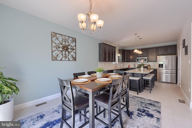 dining room featuring light tile patterned flooring, a chandelier, and baseboards
