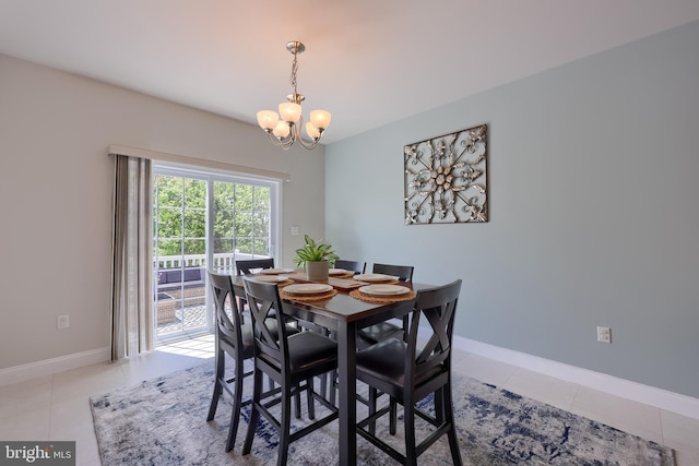 dining area with a chandelier, light tile patterned floors, and baseboards