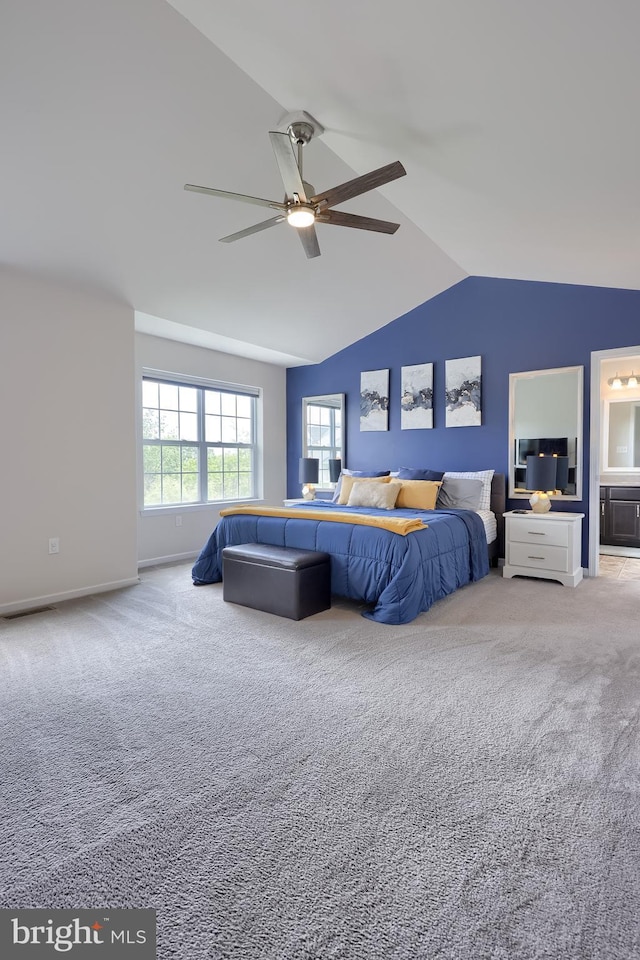 bedroom featuring carpet floors, lofted ceiling, ceiling fan, ensuite bath, and baseboards