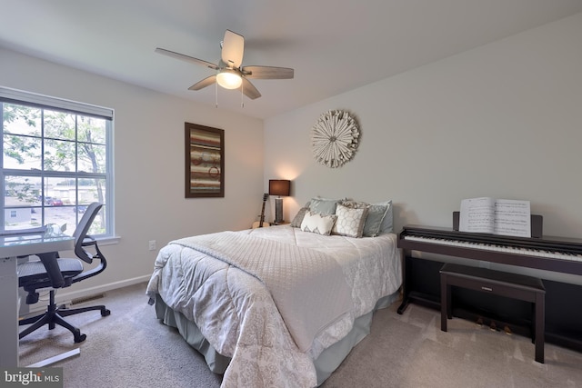 bedroom with light carpet, a desk, baseboards, and ceiling fan