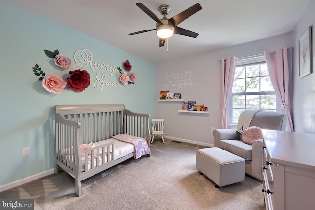 bedroom with carpet flooring, a nursery area, baseboards, and a ceiling fan