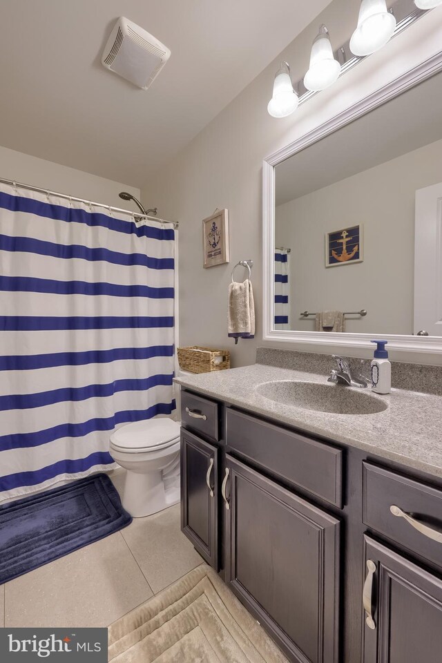 full bathroom with toilet, vanity, tile patterned floors, and curtained shower