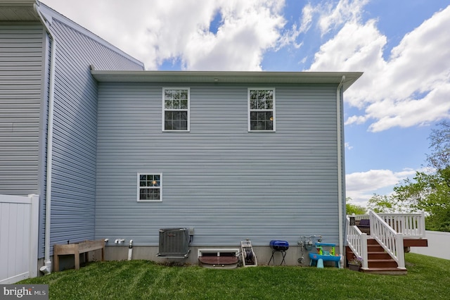 view of home's exterior featuring a lawn and central AC unit