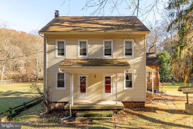 view of front facade with a chimney and roof with shingles