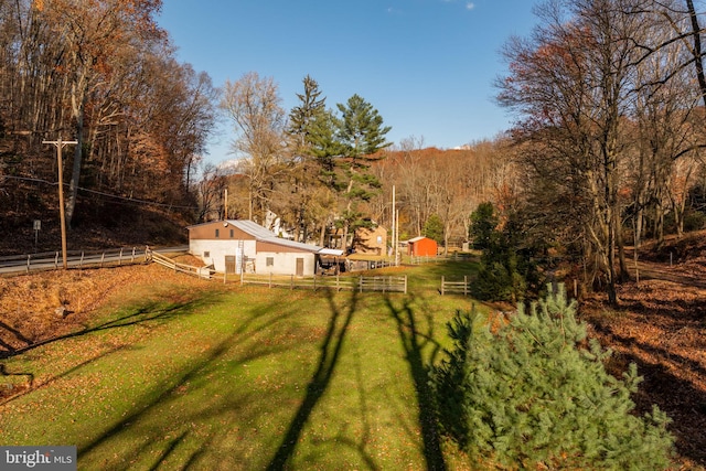 view of yard with an outbuilding and a wooded view