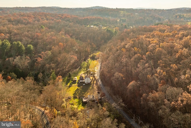 aerial view of property and surrounding area featuring a forest