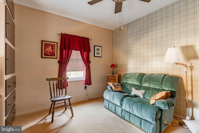 living area with a ceiling fan, carpet floors, and wallpapered walls