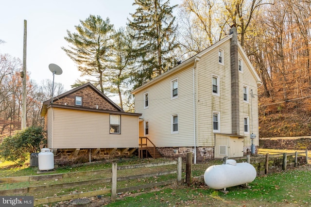 view of side of home featuring a chimney and a fenced front yard
