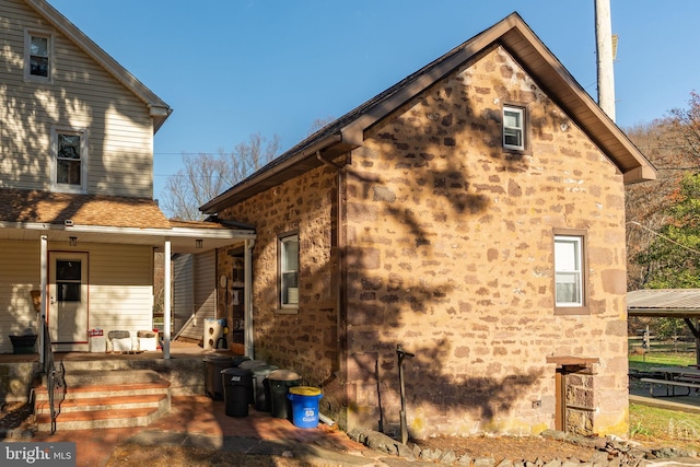 view of property exterior featuring a porch and stone siding