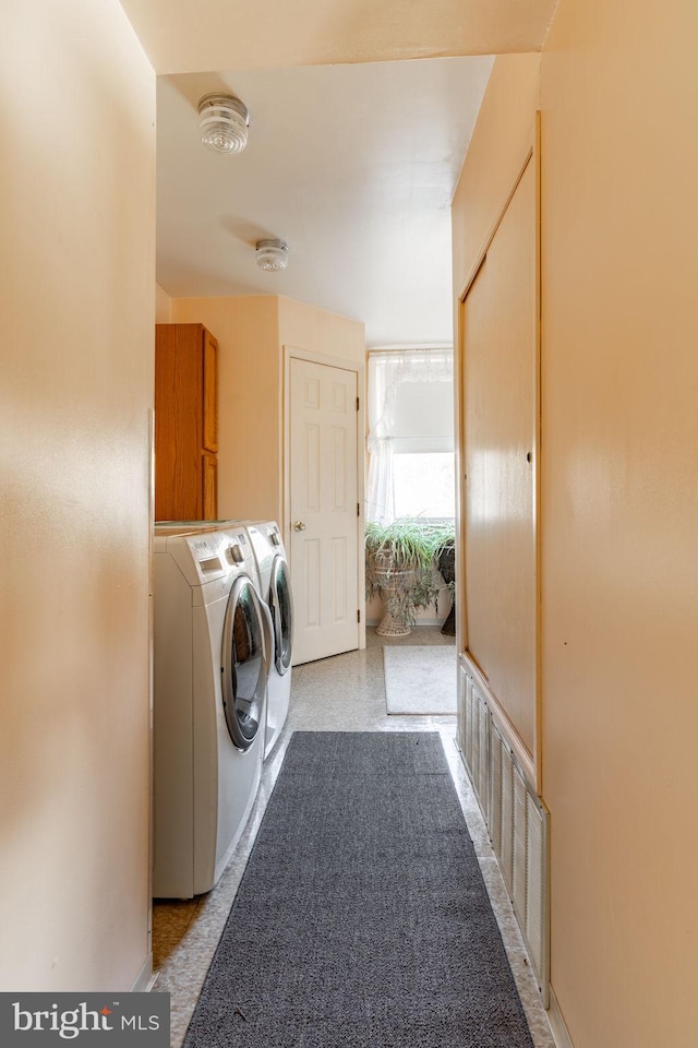 laundry area with washing machine and clothes dryer and cabinet space