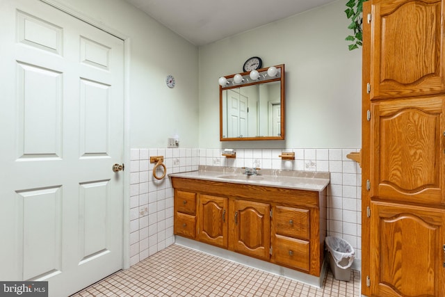 bathroom with tile walls, a wainscoted wall, vanity, and tile patterned floors