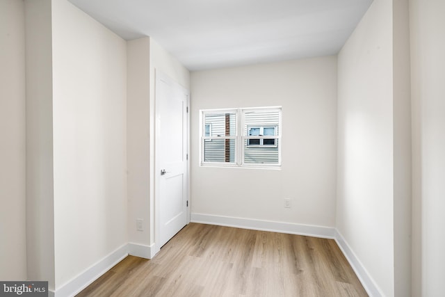 empty room with light wood-style flooring and baseboards