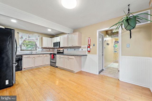 90 Echohill Ln, Willingboro, NJ 08046 - kitchen with stainless steel appliances, wainscoting, light wood finished floors, dark countertops, and a sink
