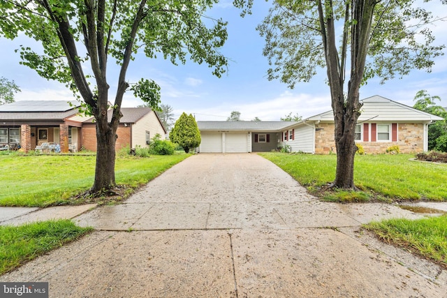 90 Echohill Ln, Willingboro, NJ 08046 - ranch-style house featuring a front lawn, concrete driveway, a garage, solar panels, and stone siding