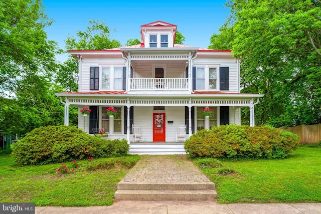 italianate home featuring covered porch, a balcony, and metal roof