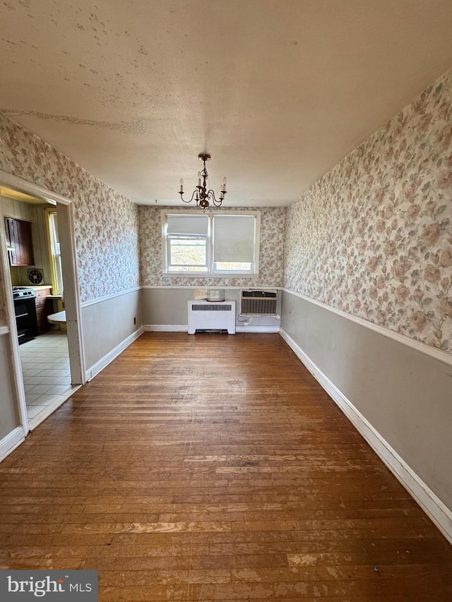 2939 Tyson Ave, Philadelphia, PA 19149 - unfurnished dining area featuring wallpapered walls, radiator heating unit, hardwood / wood-style floors, a chandelier, and a wall mounted AC
