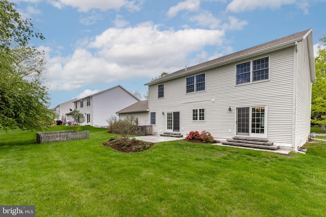 rear view of house featuring entry steps, a patio area, and a yard