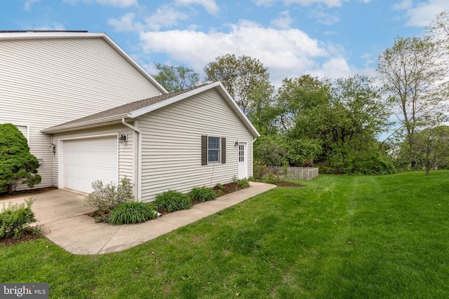 view of property exterior featuring a lawn, an attached garage, and driveway