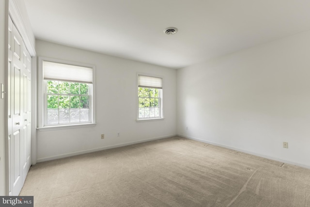 empty room featuring carpet and baseboards