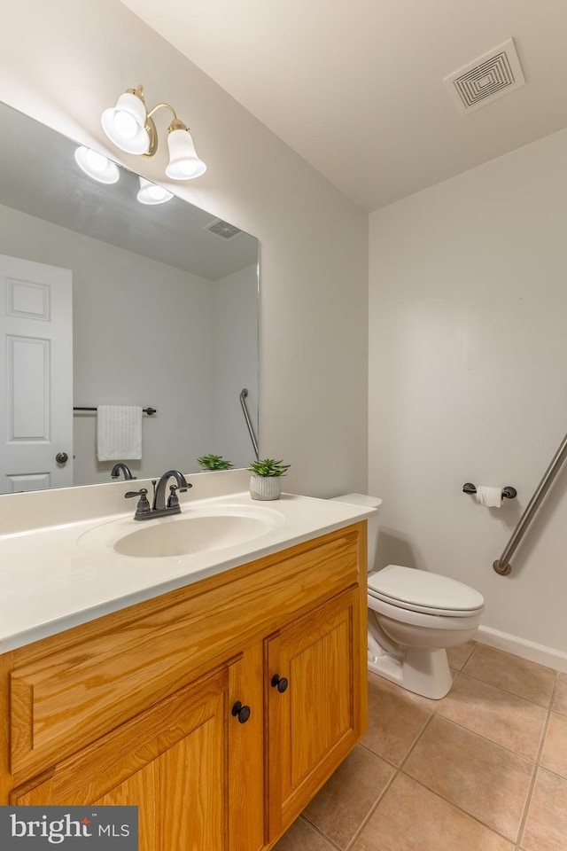 half bathroom with tile patterned floors, vanity, and toilet