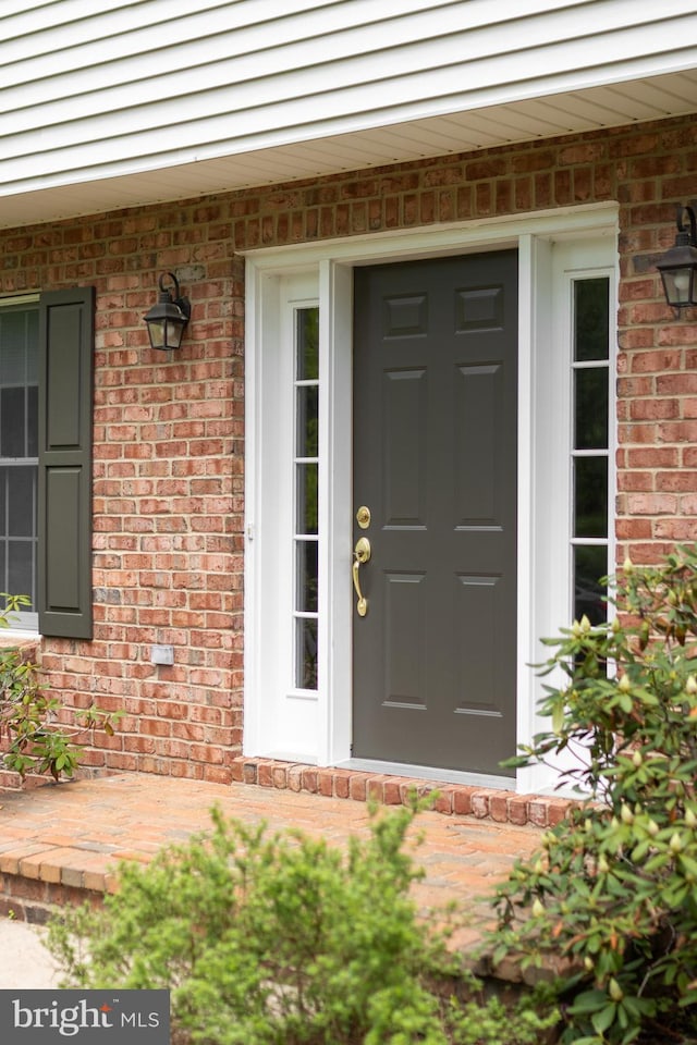 entrance to property featuring brick siding