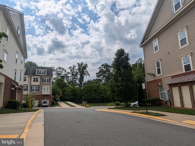 view of asphalt road with sidewalks and curbs