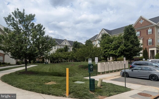 surrounding community with mail area and a yard