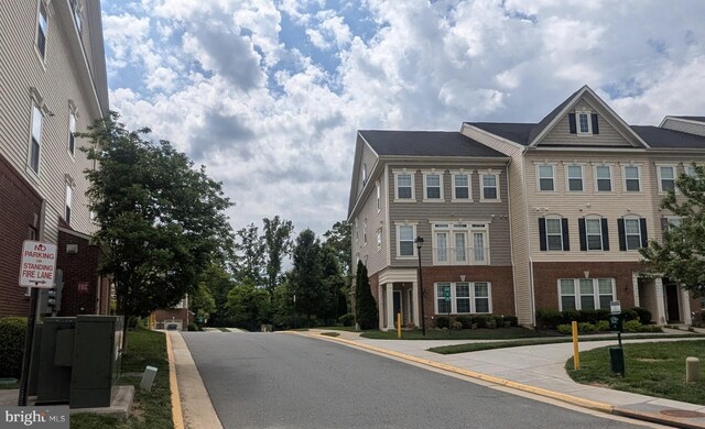 view of asphalt street featuring curbs and sidewalks