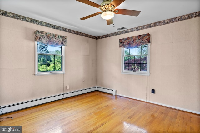 spare room with plenty of natural light, hardwood / wood-style floors, a ceiling fan, and a baseboard radiator