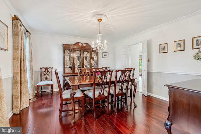 dining room featuring a chandelier, dark wood finished floors, ornamental molding, and baseboards