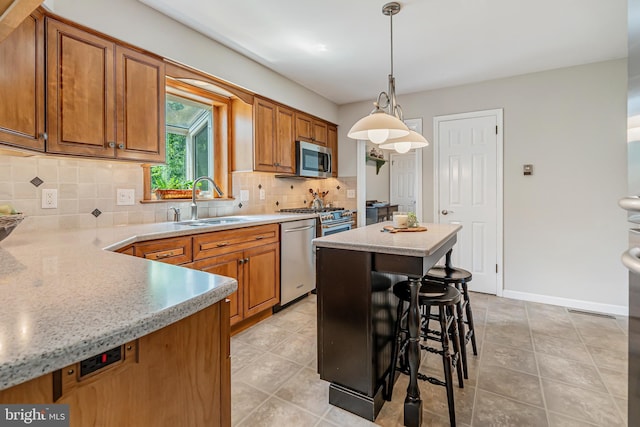kitchen with appliances with stainless steel finishes, a sink, brown cabinets, and backsplash