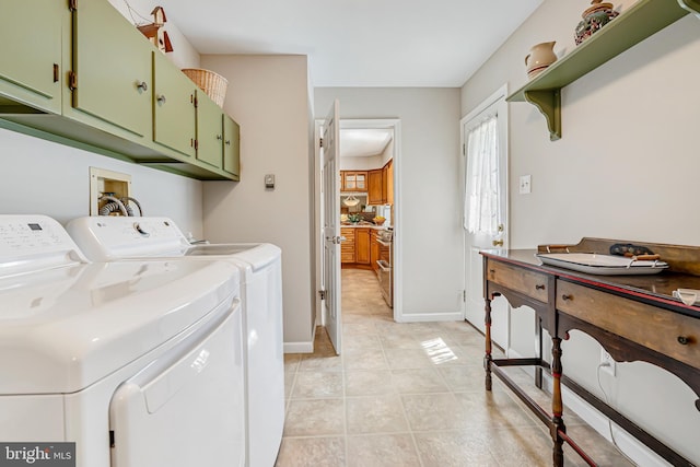 washroom featuring independent washer and dryer, cabinet space, light tile patterned flooring, and baseboards