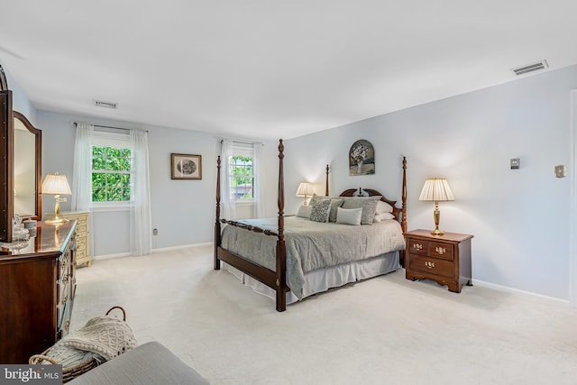 bedroom with light colored carpet and baseboards