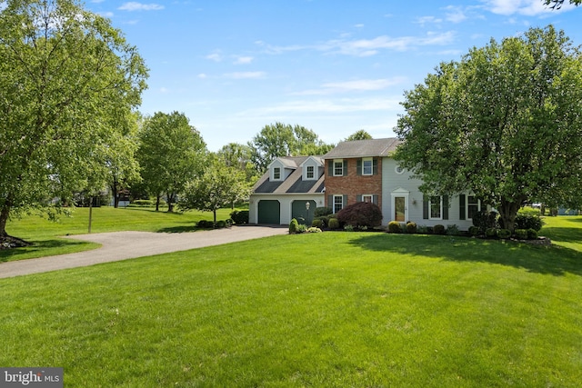 colonial home featuring driveway and a front lawn