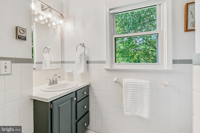 bathroom featuring tile walls, wainscoting, and vanity