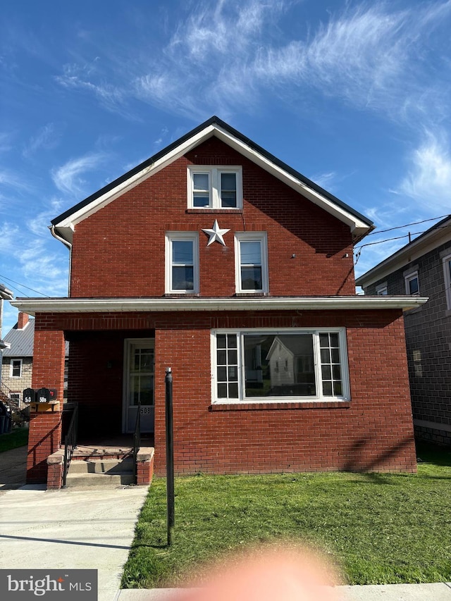 rear view of property with brick siding and a lawn
